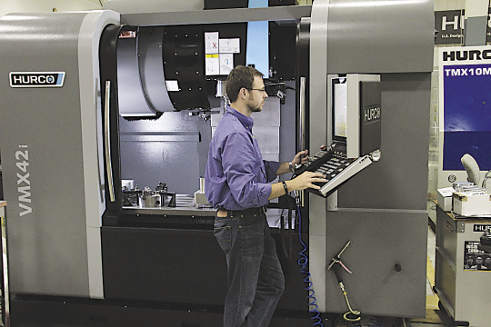 A machine operator programs a 3+2 part conversationally on Hurco’s WinMax control. Image courtesy Hurco North America.