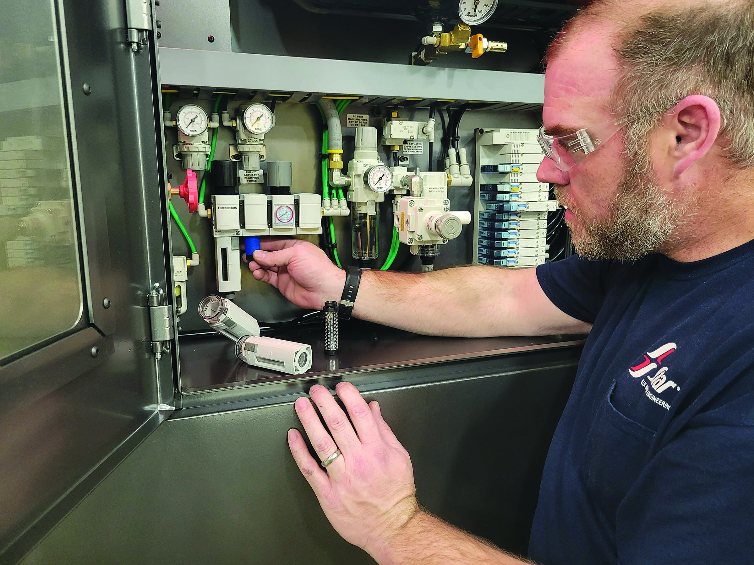 A machine operator checks and replaces rotary and linear encoder filters.