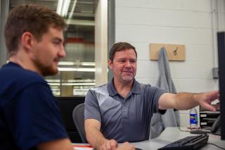 Blum apprenticeship trainer Jim Neal works with a student at the company’s factory in North Carolina