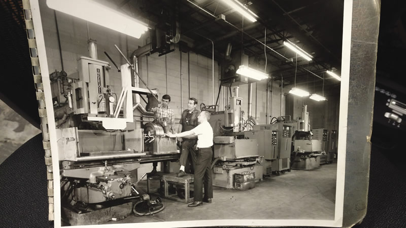 Machinists from ABET's early days, with one of the company's earliest sinker EDMs.