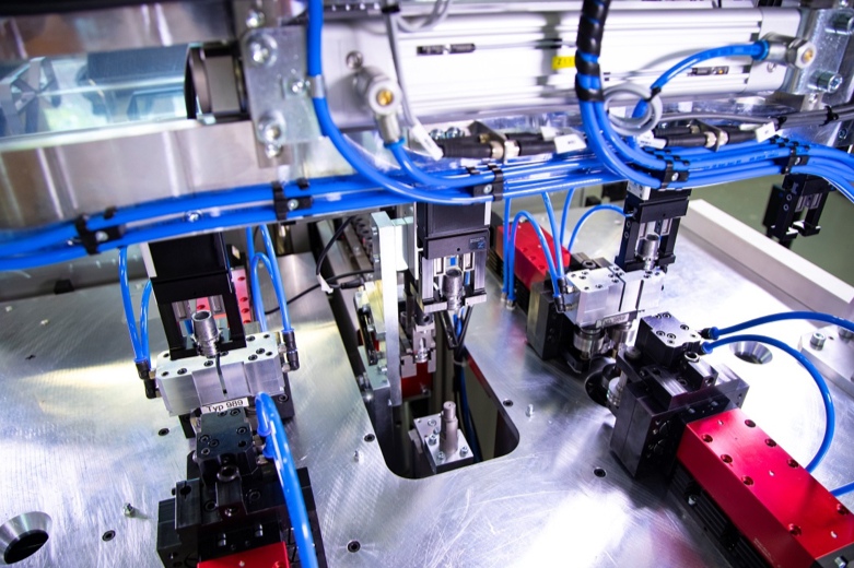 Grippers grasp battery terminals during burnishing operation