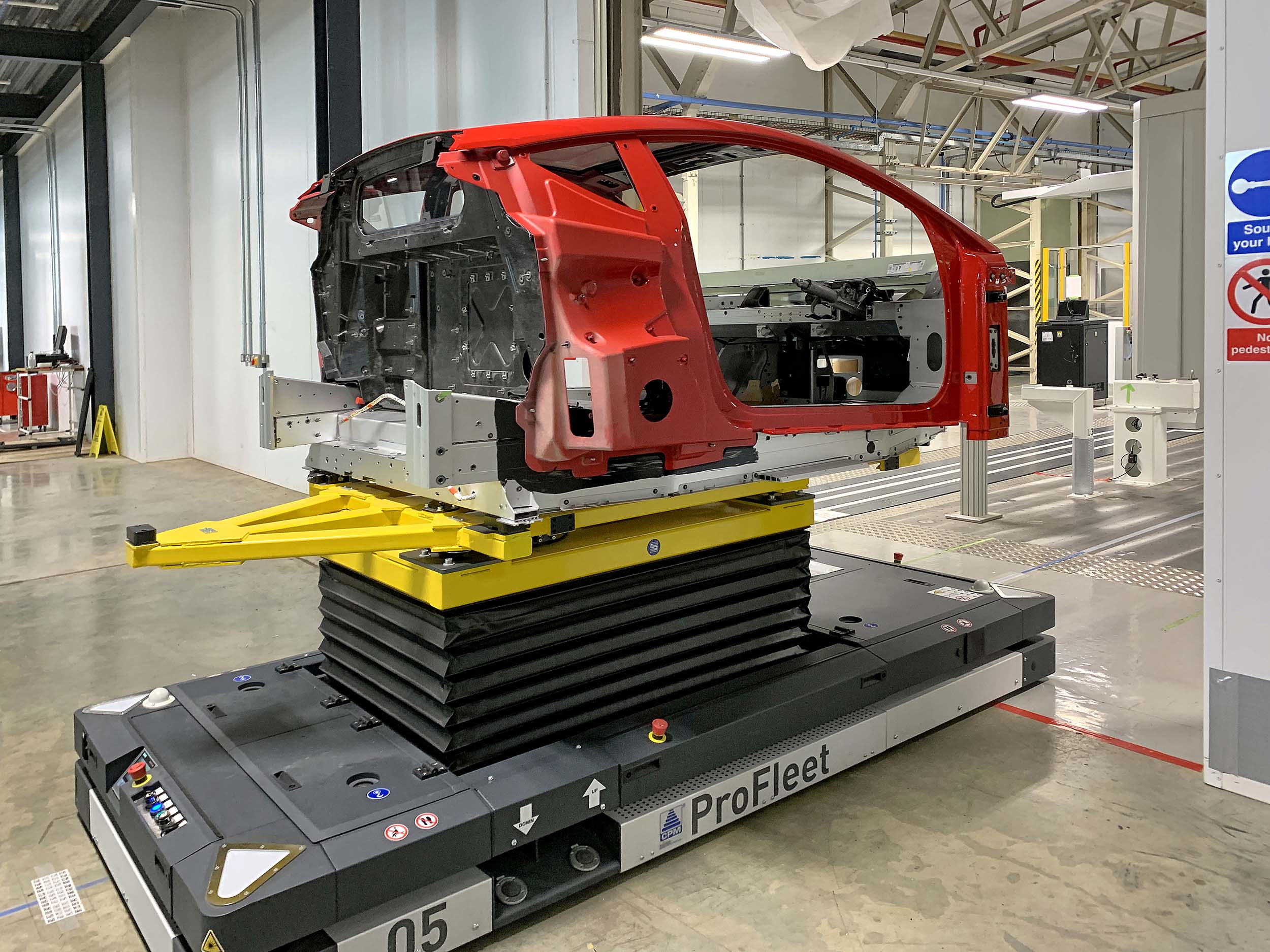 A Lotus Emira being delivered by an automated guided vehicle from the production line to the LK CMM to undergo stage 1 inspection.
